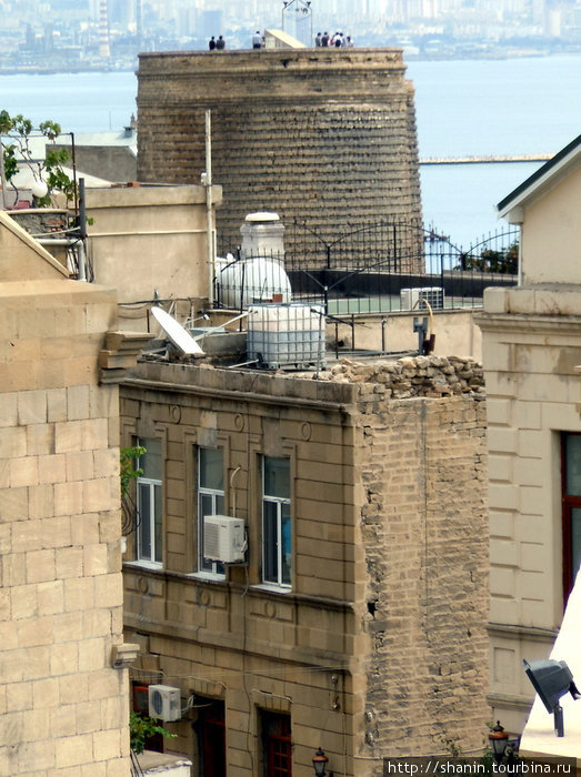 Девичья башня почти не видна за домами Баку, Азербайджан