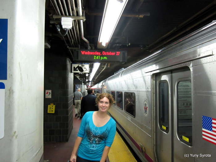 Полина на станции метро. Виден поезд и табличка с датой. Нью-Йорк, CША