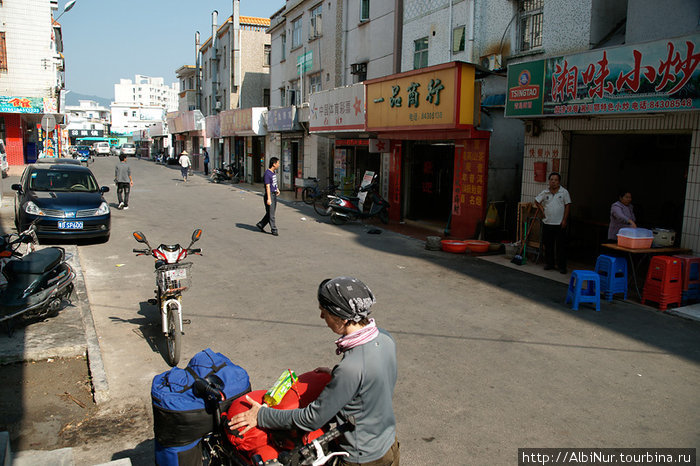 Традиционная застройка маленького города, все первые этажи заняты ремесленными лавками, едальнями и магазинами. Китай