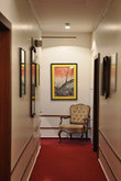Строгому коридору  добавили шарма репродукции картин и манерное кресло.