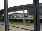 Вид на многоэтажную парковку в аэропорту О’Хара через стекло  окна  терминала.