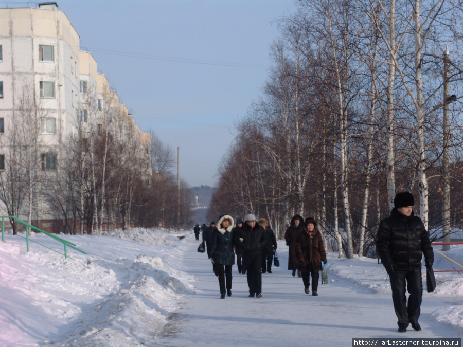 Люди идут по тротуару Тында, Россия