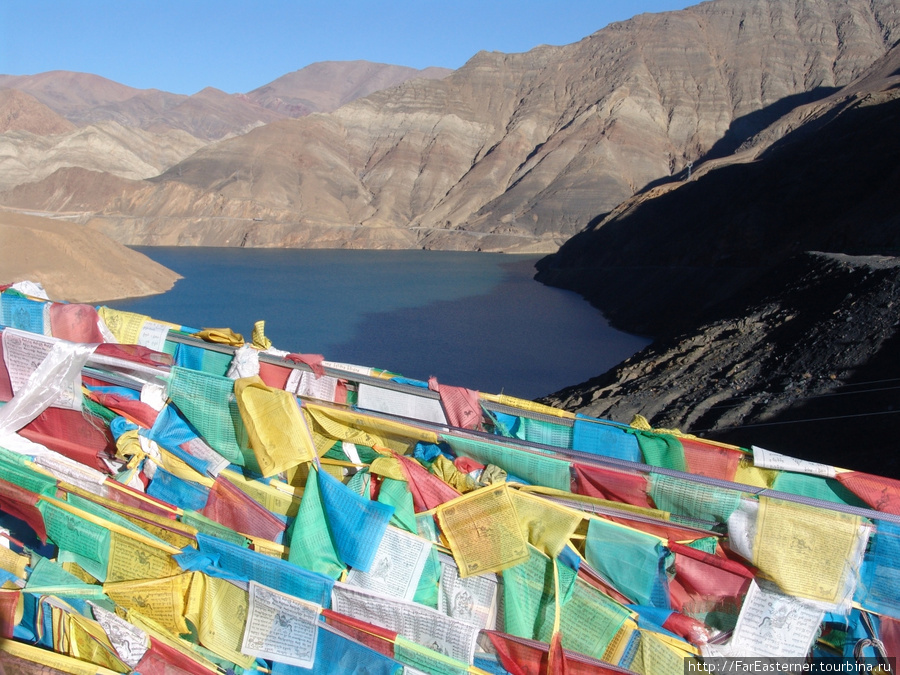 Буддистские флаги увешаны вокруг Ямдрок Цо — это одно из четырех священных озер Тибета Озеро Ямдрок, Китай