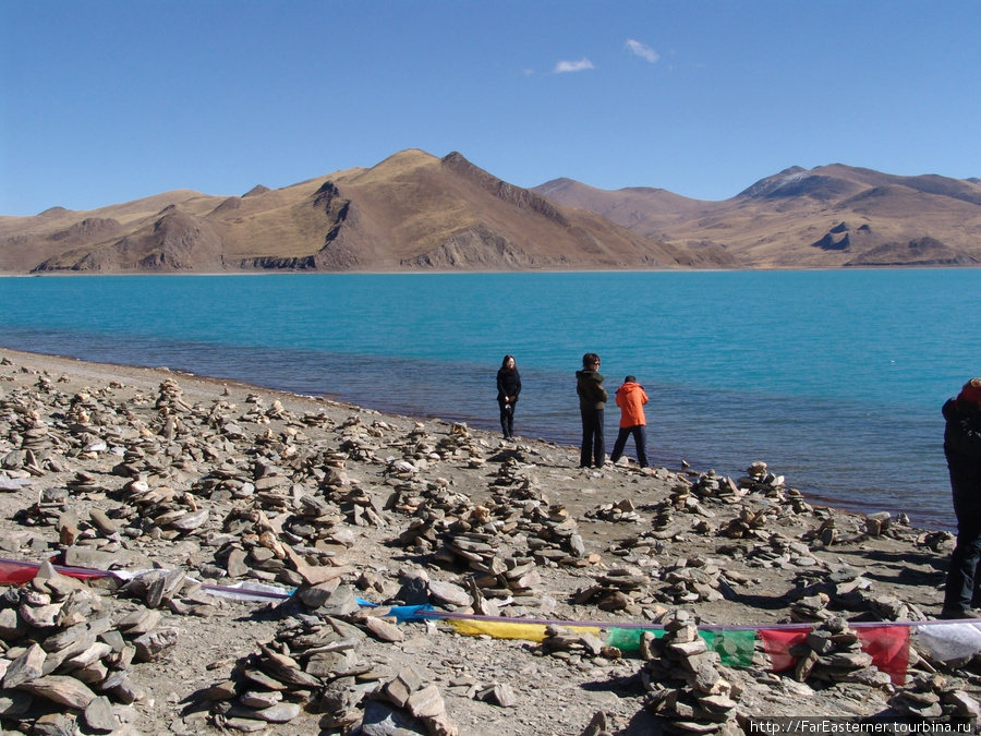 На берегу тибетцы сооружают маленькие горки камней. Это их дань местным духам Озеро Ямдрок, Китай