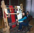 Сотрудница музея показывает, как ткут ковры
