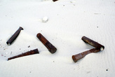 Ржавые гильзы на песке — мины под песком