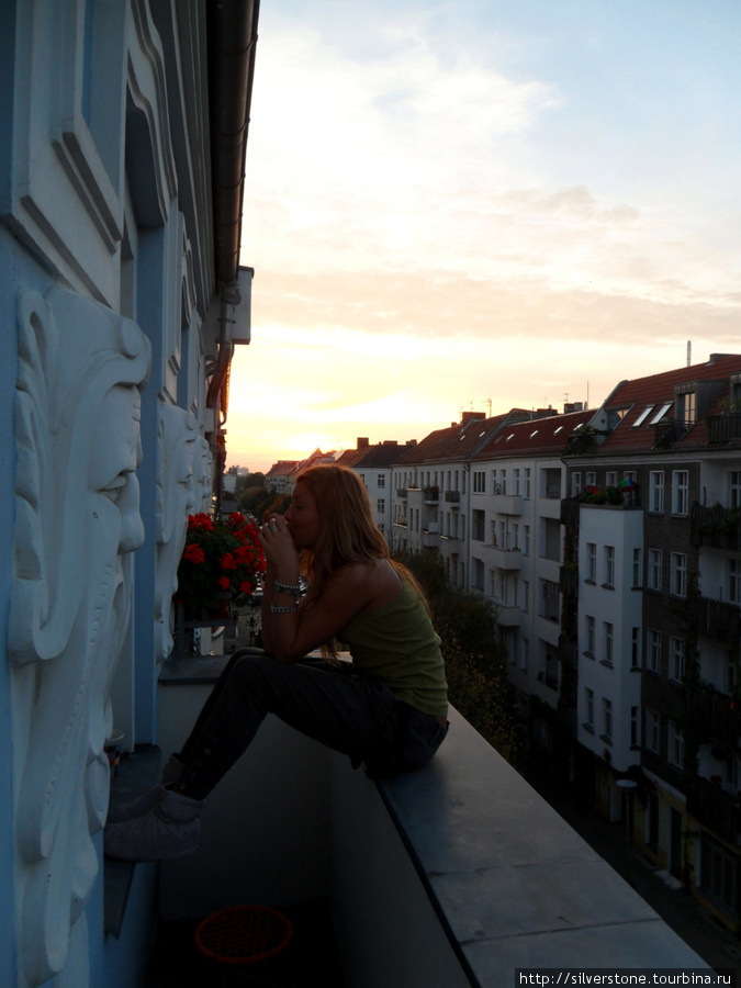 почти в центре, на балконе симпатичного немецкого домика, Настя играет на толлько что символично купленной у хозяина дома губной гармошке за 100 русских рублей Берлин, Германия