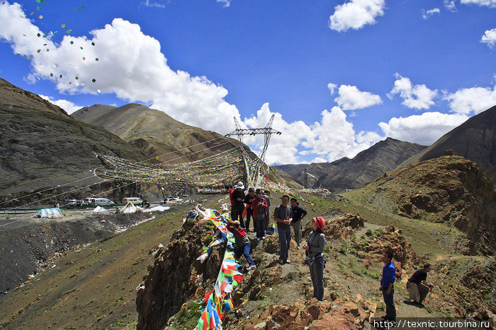 На перевале туристы бросают вверх листки с молитвами. Озеро Ямдрок, Китай