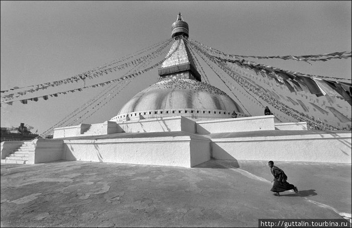 Молодой монах бежит возле ступы Буднатх а Катманду. Непал