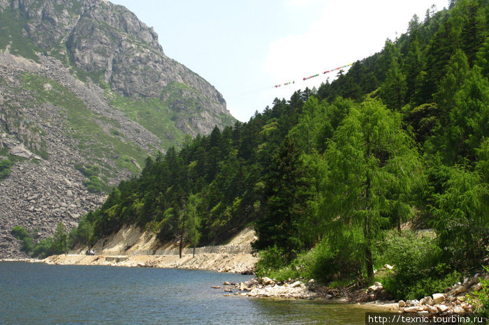 Через ущелье растянуты молельные флаги Озеро Мугекуо, Китай