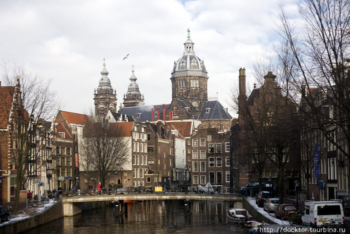 С канала Аудезейдс-Фоурбургвал открывается вид на церковь Синт-Николаскерк Амстердам, Нидерланды