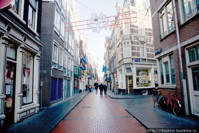 Warmoesstraat — справа начинается Красный квартал Амстердам, Нидерланды