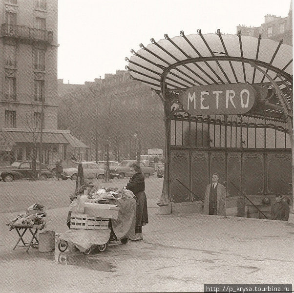 Стеклянный вход. Площадь Нации 1950 год. Постоянная торговка разложила овощи перед открытым стеклянным входом в метро. Париж, Франция