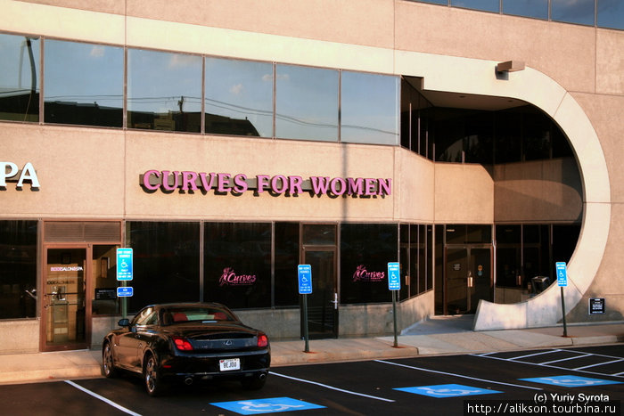 Надпись: Curves for Women. То есть, изгибы (или округлости) для женщин. Это спорт зал. Перед ним стоит очень округлый Лексус;) Маклин, CША