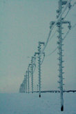 Электрические столбы и провода с намерзшим снегом.