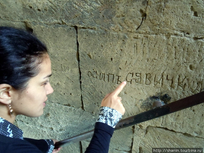 Экскурсовод обрашает внимание на старые графитти Баку, Азербайджан