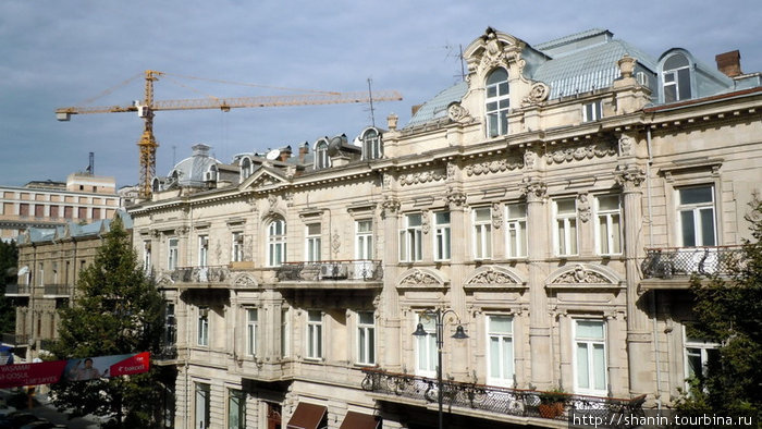 Обычная картина — строительный кран над старыми домами Баку, Азербайджан