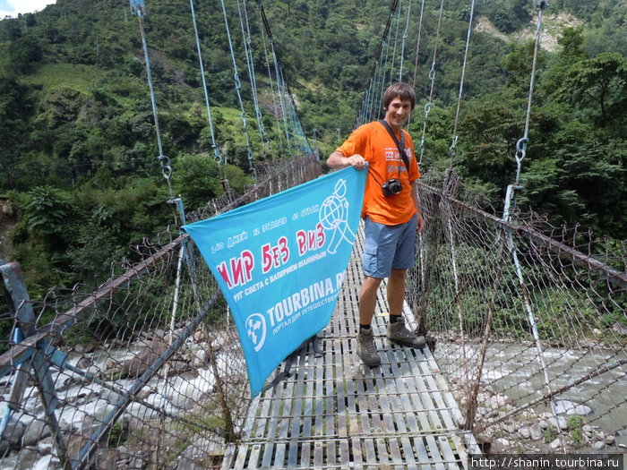Олег Семичев с флагом  Мир без виз на подвесном мосту Бесисахар, Непал