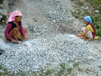 Женщина вручную дробят камни, чтобы сделать гравий