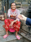 Женщина у входа в храм собирает пожертвования