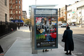 Гарлем. Чёрная старушка на автобусной остановке.
Надпись на рекламе: видь больше — будь больше.