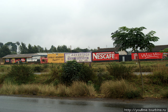реклама и мокрая от дождя дорога Провинция Найроби, Кения