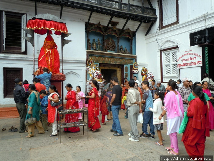 Паломники у статуи матери-богини перед входом в Королевский дворец Катманду, Непал