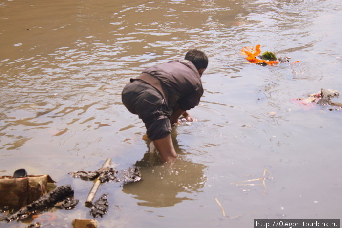...кто то из реки вытаскивает выброшенные вещи для повторного их использования Непал