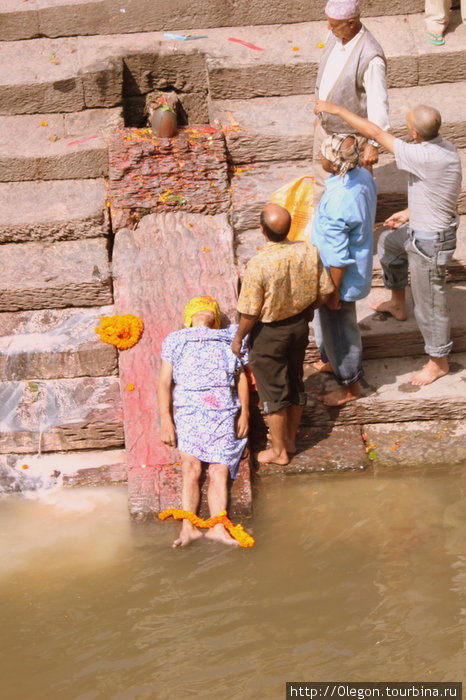 Тело мёртвых приносят на реку, раздевают под простынёй, моют в священной реке... Непал