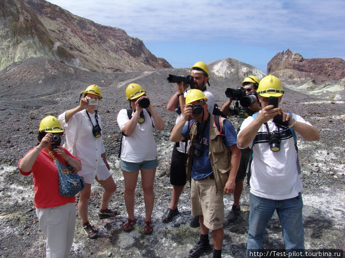 Группа фотографов в касках. Каски выдают всем на случай извержения вулкана, чтобы извергающиеся камни падали на голову защищенную. Типа так будет не больно. Белый остров, Новая Зеландия