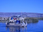 Туристы катаются на тростниковых лодках вокруг островов. Под перуанским влагом — местные индейцы патриоты.