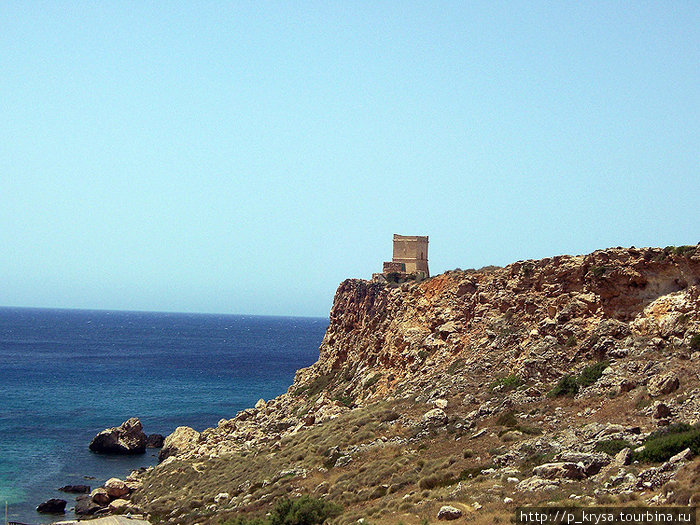 Справа от скалы над пляжем возвышается рыцарская сторожевая башня. Айн Туффиха, Мальта