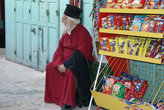 усталый священник-грек присел на стульчик продавца, а получилось, что он и есть сам продавец)))