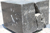 Куб из чёрного мрамора расколотый землетрясением, на одной стороне дата, на другой время начала стихии