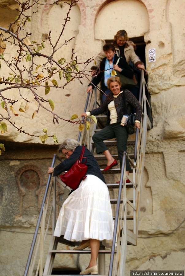 Туристы выходят из церкви Гёреме, Турция