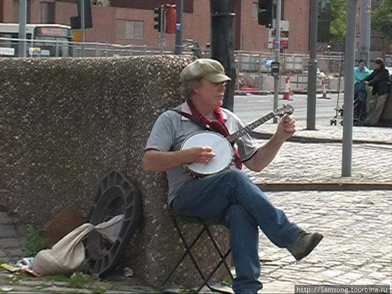 Уличный музыкант наигрывает мелодию Битлз. Ливерпуль, Великобритания