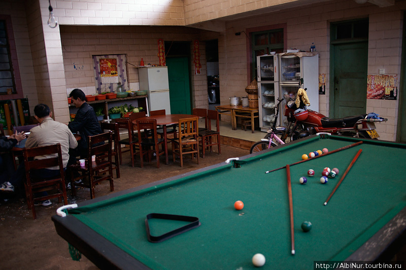 А вот и чифанька в китайском стиле: в одном помещении кухня, гараж и игровой зал. Провинция Юньнань, Китай