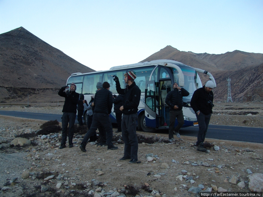 Продрогшие и шокированные высотой туристы вылезли из автобуса чтобы размяться Тибет, Китай