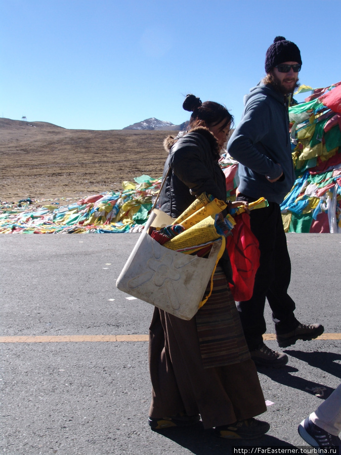 Эта женщина продавала тибетские буддистские флаги туристам по 4 юаня за связку. Тибет, Китай