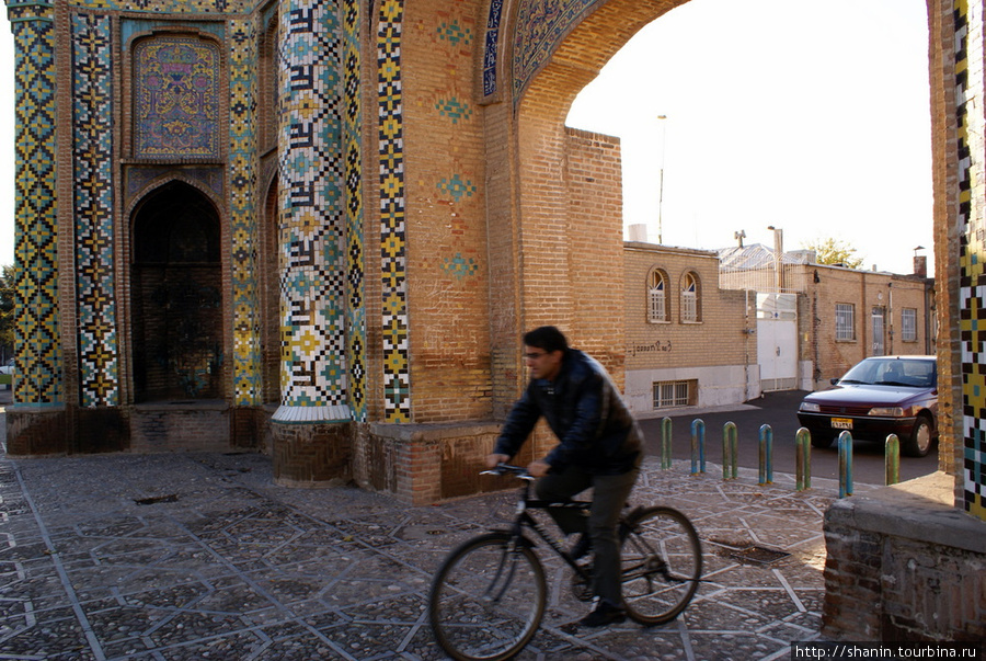 Велосипедист проезжает через ворота Ра Кушк Казвин, Иран