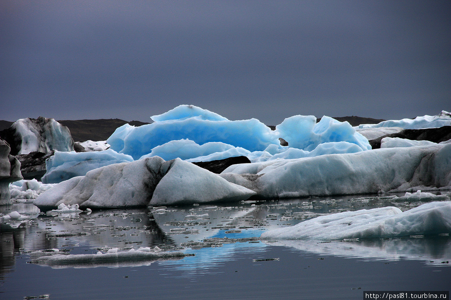 На экскурсии рассказывают, почему лед синий. Вода, даже в виде льда, абсорбирует весь спектр, кроме синего, который отражается. Но чтобы этого добиться, лед должен быть довольно толстым. И гладким. После переворота айсберг синий. Но потом верхний слой подтаивает и становится белым. Йёкюльсаурлоун ледниковая лагуна, Исландия