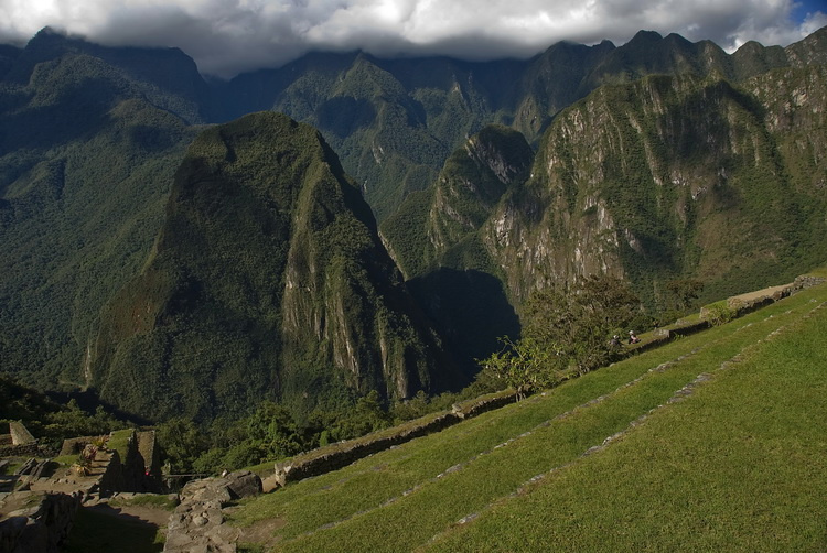 Горы, тёмно-зелёными мохнатыми кеглями обступили Мачу Пикчу, надвинув облака на лоб. Мачу-Пикчу, Перу