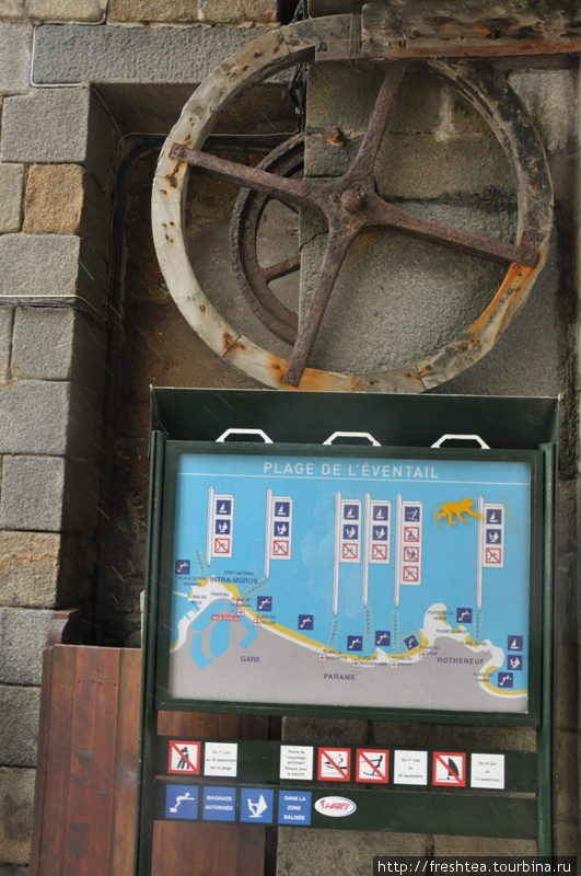 О режиме прихода воды к берегам Сен-Мало информируют плакаты, как этот, у Старых ворот. Створки ворот все еще движет специальная система передач. Бретань, Франция
